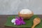 Cooked rice in bowl on green banana leaf and paddy in spoon and orchid .