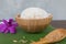 Cooked rice in bowl on green banana leaf and paddy in spoon and orchid .
