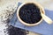 Cooked riceberry and a wooden spoon in a wooden cup and placed on a cloth