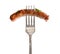 Cooked sausage chipolatas on a fork isolated on white background