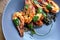 Cooked shrimps,prawns with seasonings on stone background. Fried shrimp with rosemary in a portioned frying pan on a dark table to