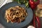 Cooked soba on a plate next to spices, pepper and garlic