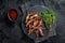Cooked Spicy fried duck tongue. Black background. Top view