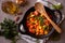 Cooked various chopped vegetables with herbs in a black cooking pot