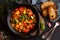 Cooked various chopped vegetables with herbs in a black cooking pot