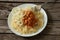 Cooked vermicelli with beans in tomato and onion in a white plate lies on a wooden old board