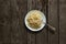 Cooked vermicelli in a white plate lies on a wooden old board