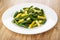Cooked yellow and green beans in plate on wooden table