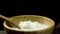 Cooked, yummy, hot rice with steam in wooden pot and big spoon, isolated on black background. Close up for deep dish