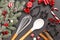 Cookie cutters with spoon, whisk, cinnamon sticks, sweets, lollypops  for Christmas baking, fir branches on slate