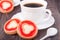 Cookie with jelly and cup of coffee on wooden table