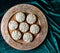 Cookie rose design on wooden plate with green velvet background