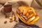 Cookies, bagels, chocolate cakes and star anise in a wicker basket and a glass of tea in a vintage Cup holder on a background of