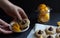 cookies with chocolate candy kiss, sliced orange pieces, hand holds plate with desert