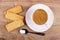 Cookies with filling, cup of coffee on saucer, spoon on table. Top view