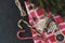 Cookies in the form of Christmas trees on a red napkin in a cage, candy, cinnamon, star anise, spruce branch on a black background