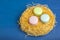 Cookies, macaroni in a birds nest on a blue background. Easter theme. View from above