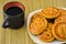 Cookies on a plate and a cup of coffee in a black mug. View from above