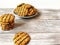 cookies poured with chocolate and pieces of peanuts is a slide on a white plate on a light table