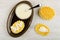 Cookies poured on milk, teaspoon, bowl with condensed milk in dish, stack of cookies on table. Top view