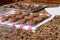 Cookies in the process of being made with cookie dough balls on a baking sheet and freshly baked cookies cooling on wire rack