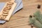 Cookies with raisins on board. Gray napkin sprig of fir and cones on table