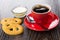 Cookies, red cup with coffee, spoon, condensed milk in bowl