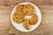 Cookies with sesame and flax seeds, broken cookie in plate on table. Top view