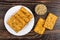 Cookies with sunflower seeds in plate, peeled seeds in bowl on dark wooden table. Top view