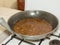 Cooking Bagoong on a large pan on a stove. Bagoong is made of either fermented fish or krill or shrimp paste with salt