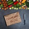 Cooking blog concept. Vegetables, empty sheet of crumpled paper and chef`s knife on a black background