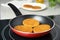 Cooking breaded cutlets in frying pan on stove