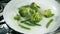 Cooking broccoli and green beans in a frying pan. Slow motion.