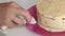 Cooking carrot cake. The woman removes the remains of the cream with a napkin. Close-up shot