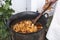 Cooking chicken stew in a cauldron