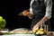 Cooking the chief of fresh fish, the chef salt fish on a black background with lemons, limes