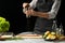 cooking the chief of fresh fish, the chef sprinkles the seasoning fish on a black background with lemons, limes, rosemary and thym