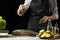 cooking the chief of fresh fish, the chef sprinkles the seasoning fish on a black background with lemons, limes, rosemary and thym