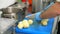 Cooking. close-up, the chef, in protective gloves, is cutting boiled potatoes on cooking board. health food and safety