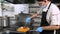 Cooking. close-up. the cook, in protective mask and gloves, stirring the frying onions and carrots in frying pan. health