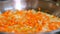 Cooking. close-up, onions with carrots are fried in a pan. vegetable oil boils and bubbles, steam goes. health food and