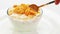 Cooking corn flakes with milk in a glass bowl