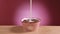 Cooking delicious breakfast of chocolate cornflakes in form of balls and milk in slow motion on pink background. Cereals