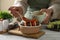 Cooking delicious ratatouille. Woman dressing fresh vegetables in bowl at white wooden table, closeup