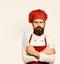 Cooking equipment and cuisine concept. Cook with serious face in burgundy apron and chef hat.