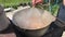 Cooking fish soup in a hiking pot on the street on a grill.