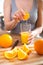 Cooking, food and concept of veganism, vigor and healthy eating - close up of female hand squeeze fresh orange juice