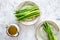 Cooking fresh asparagus. Greens on plate near a jug of oil on grey stone background top view