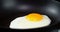 Cooking fried eggs in a pan with hot steam.