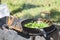 Cooking fried onions in a vintage iron skillet over a burning fire. Cooking at the suburban area. Close-up